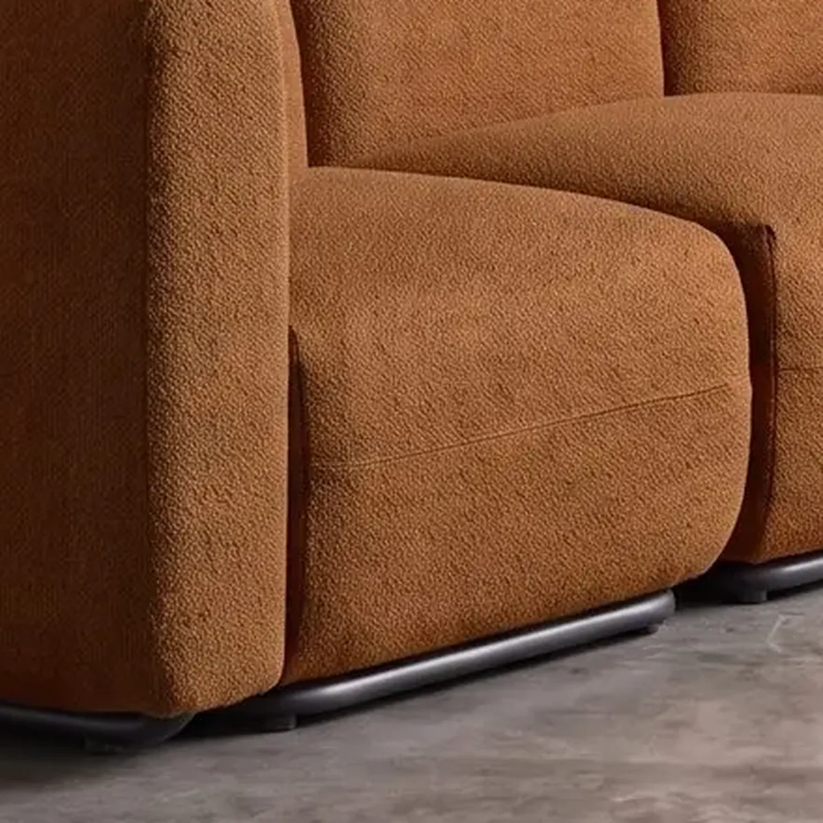 Detalhe do tecido bouclê caramelo no braço de um sofá — estudo gerado